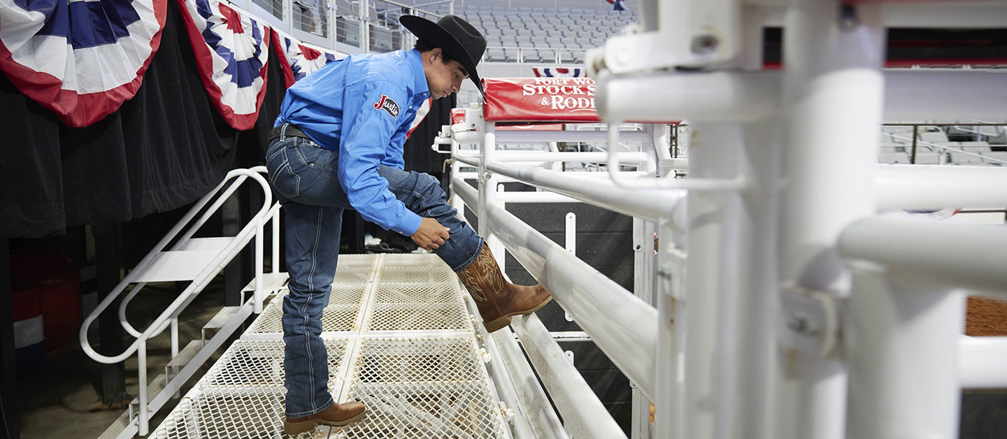 Laramie Mosley models a brown boot with his foot propped up on the chutes at the Fort Worth Stock Show & Rodeo.